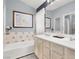 This bathroom features dual sinks, a large mirror, and an elegant tub with blue and white patterned tilework at 1861 Windward Ct, Henderson, NV 89012