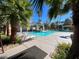 A community pool featuring palm trees, lounge chairs, and a covered area to relax out of the sun at 1861 Windward Ct, Henderson, NV 89012