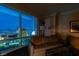 Comfortable living room features a sofa, floor lamp, and stunning views of the city skyline at night at 2000 Fashion Show Dr # 5509, Las Vegas, NV 89109