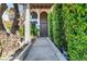 Welcoming front entrance featuring an arched doorway, well-manicured shrubs, and mature trees at 2017 Plaza De Cielo, Las Vegas, NV 89102