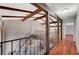Unique hallway with decorative wood beams, iron staircase, and modern chandelier at 2017 Plaza De Cielo, Las Vegas, NV 89102