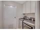 Convenient laundry room with modern washer and dryer units and white cabinets for storage at 2017 Plaza De Cielo, Las Vegas, NV 89102