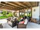 Large, covered patio area with comfortable seating and easy access to a spiral staircase and lush landscaping at 2017 Plaza De Cielo, Las Vegas, NV 89102