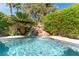 Inviting pool area features a rock waterfall, mature landscaping, and clear, blue water at 2017 Plaza De Cielo, Las Vegas, NV 89102