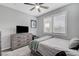 Well-lit bedroom with ceiling fan, plantation shutters, gray dresser, and comfortable bed for a relaxing ambiance at 2115 Noble Perch St, Las Vegas, NV 89138