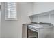 Laundry room featuring modern washer and dryer units with shelving and a window for natural light at 2115 Noble Perch St, Las Vegas, NV 89138