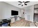 Living room with tile floors, ceiling fan, TV, and staircase to the second level at 2115 Noble Perch St, Las Vegas, NV 89138