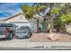 Charming single-story home featuring a two-car garage, desert landscaping, and mature shade tree at 2301 Cambridge Elms St, North Las Vegas, NV 89032