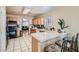 Well-lit kitchen features wooden cabinets, tiled countertops, and a convenient breakfast bar at 2301 Cambridge Elms St, North Las Vegas, NV 89032