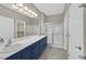 This bathroom features double sinks, a glass shower, and bright vanity lighting at 2525 Willow Wren Dr, North Las Vegas, NV 89084
