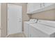 The laundry room features white washer, dryer, cabinets, and access door at 2525 Willow Wren Dr, North Las Vegas, NV 89084