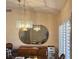 Dining room features elegant lighting, a round mirror, plantation shutters, and classic furniture at 2708 Hope Forest Dr, Las Vegas, NV 89134
