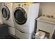 Laundry room with white washer and dryer and utility sink at 2708 Hope Forest Dr, Las Vegas, NV 89134