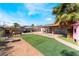 Lush backyard featuring green lawn, palm tree, patio, and small storage shed at 2732 Johannson Ln, Las Vegas, NV 89115