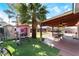 Spacious backyard featuring a covered patio, green turf, playhouse, and mature palm tree at 2732 Johannson Ln, Las Vegas, NV 89115