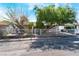 Street view of a cozy single-story home featuring a metal fence, mature trees, and front yard landscaping at 2732 Johannson Ln, Las Vegas, NV 89115