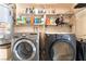 Well-equipped laundry area with washer, dryer, and overhead shelving for storage at 2732 Johannson Ln, Las Vegas, NV 89115