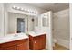 Bathroom featuring double sinks, oak cabinets, an oversized mirror, and a combination shower and tub at 2801 N Rainbow Blvd # 102, Las Vegas, NV 89108