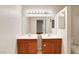 Well-lit bathroom featuring dual sinks, oak cabinets, a large mirror, and a combination shower and tub at 2801 N Rainbow Blvd # 102, Las Vegas, NV 89108