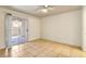 This bedroom features tile flooring, a ceiling fan, and a sliding glass door to a private patio at 2801 N Rainbow Blvd # 102, Las Vegas, NV 89108