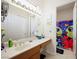 Bathroom featuring double sinks, storage, and shower and tub combo with colorful curtain at 2962 Gettysburg Ave, Henderson, NV 89052