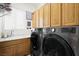 Functional laundry room with modern washer and dryer, wood cabinets, and sink at 2962 Gettysburg Ave, Henderson, NV 89052