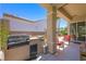 Covered patio featuring built-in outdoor kitchen with grill, seating area, and well-manicured landscape at 2962 Gettysburg Ave, Henderson, NV 89052
