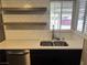 Updated kitchen sink with stainless steel dishwasher, open shelving and subway tile backsplash at 30 Diamond Cir, Las Vegas, NV 89106