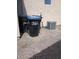 Backyard view features trash bins, an air conditioning unit, gravel landscape, and a building with stucco walls at 3012 Silver Canyon Ln, North Las Vegas, NV 89031
