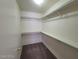 A neutral colored walk-in closet with hanging rods and shelving at 3012 Silver Canyon Ln, North Las Vegas, NV 89031