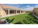 Spacious backyard features lush artificial turf, a covered patio and low-maintenance landscaping at 3032 Bonnie Rock Dr, Las Vegas, NV 89134