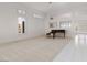 Bright living room with large windows, neutral carpet, and a beautiful piano at 3032 Bonnie Rock Dr, Las Vegas, NV 89134
