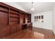 Home office with dark wood built-in bookshelves, a desk, and hardwood floors at 3032 Bonnie Rock Dr, Las Vegas, NV 89134