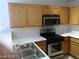 Updated kitchen with stainless steel stove and microwave, light wooden cabinets and white countertops at 3401 Conan St # 103, Las Vegas, NV 89129