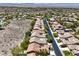 Neighborhood aerial view showcasing lush landscaping, tile roofs, and the nearby desert landscape at 35 Glade Water Dr, Henderson, NV 89052