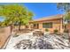 Landscaped backyard with desertscape gravel, a stone fire pit, and views of the home at 35 Glade Water Dr, Henderson, NV 89052
