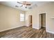Bright bedroom with neutral walls and wood-look floors featuring a ceiling fan and two doorways at 35 Glade Water Dr, Henderson, NV 89052