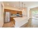 Modern kitchen with a center island, stainless steel appliances, and access to the backyard through glass doors at 35 Glade Water Dr, Henderson, NV 89052