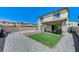Wide view of backyard featuring artificial grass, gravel landscaping, and a covered patio at 351 Nativo Ave, North Las Vegas, NV 89031