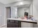 Primary bathroom featuring a spacious granite vanity, a sink, and a large mirror with access to a walk-in closet at 351 Nativo Ave, North Las Vegas, NV 89031