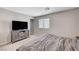Comfortable bedroom with a large TV, wooden dresser, neutral carpet, and a window at 351 Nativo Ave, North Las Vegas, NV 89031
