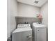 Functional laundry room with a white washer and dryer, featuring a shelf, and minimalist design at 351 Nativo Ave, North Las Vegas, NV 89031