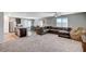 Open-concept living area with plush carpeting, a large sectional sofa, and views to the dining area at 351 Nativo Ave, North Las Vegas, NV 89031