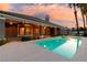 Beautiful backyard featuring a sparkling pool, covered patio, and lush landscaping, perfect for outdoor living at 3684 Mooncrest Cir, Las Vegas, NV 89129