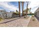 Paver patio leads to a pool surrounded by palm trees and desert landscaping at 3684 Mooncrest Cir, Las Vegas, NV 89129