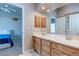 Well-lit bathroom with double sinks, wood cabinets, and a view into the bedroom at 3684 Mooncrest Cir, Las Vegas, NV 89129