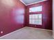 Bedroom featuring textured walls, carpet flooring, and a window with plantation shutters at 3684 Mooncrest Cir, Las Vegas, NV 89129