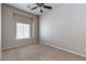A simple bedroom with neutral tones, carpet flooring, ceiling fan and recessed window at 3684 Mooncrest Cir, Las Vegas, NV 89129