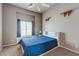 Carpeted bedroom with a blue bedspread, bright window, shelves, and neutral walls at 3684 Mooncrest Cir, Las Vegas, NV 89129