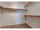 A clean walk-in closet with white walls, wooden rods and shelving at 3684 Mooncrest Cir, Las Vegas, NV 89129